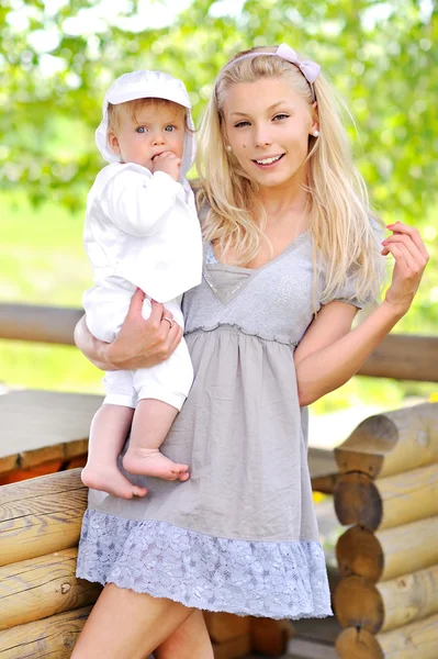 Jonge mooie moeder met haar kleine babyjongen buitenshuis — Stockfoto