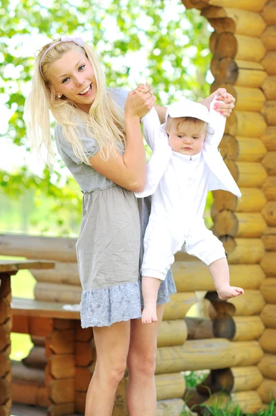 Jovem bela mãe brincando com seu pequeno filho — Fotografia de Stock