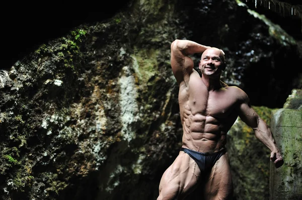 Stock image Young bodybuilder in a cave