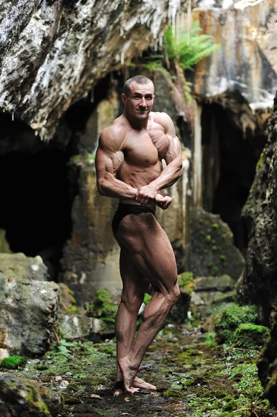 Silný muž trup ukazuje biceps - Plná délka portrét — Stock fotografie