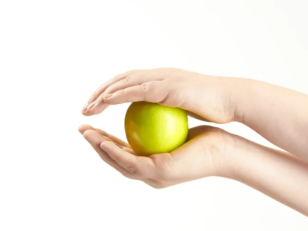 Яблоко, зажатое между детскими руками — стоковое фото