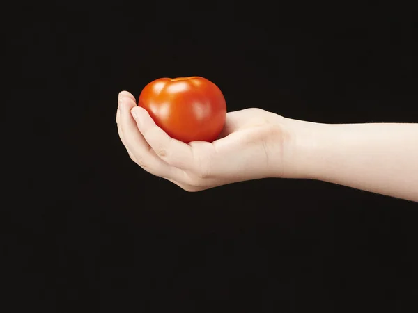 Main d'enfant avec tomate et paume tournée vers le haut — Photo