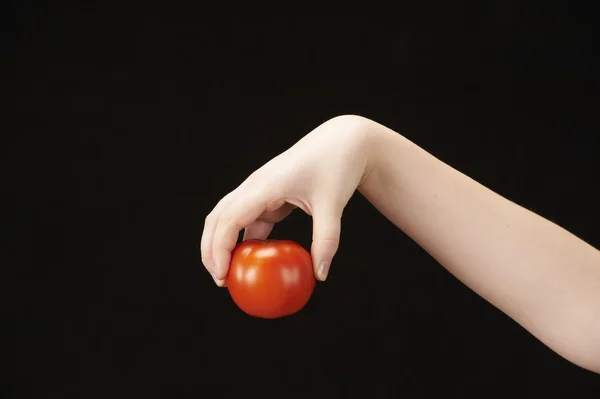 Рука ребенка с томатом — стоковое фото