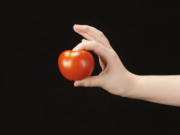 Barnets hand med tomat — Stockfoto
