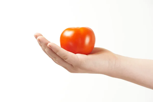 Main d'enfant avec tomate et paume tournée vers le haut — Photo