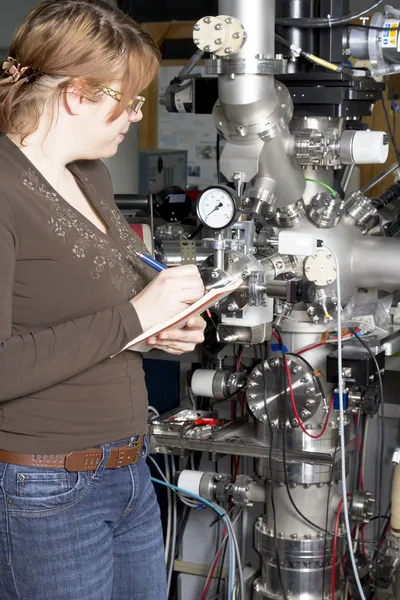 이온 가속기의 전자 부품을 검사 하는 젊은 과학자 — 스톡 사진