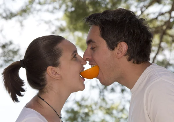 吃一个新鲜橘子的年轻夫妇 — 图库照片