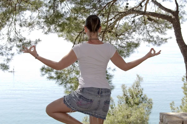 Menina realizando ioga perto do mar — Fotografia de Stock