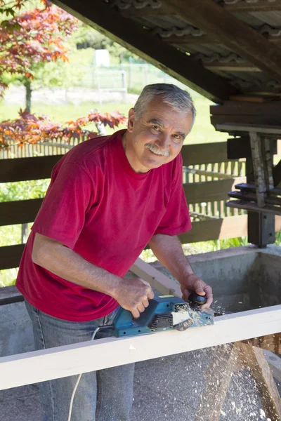 Счастливый плотник-фрезеровщик с электроплоским инструментом — стоковое фото