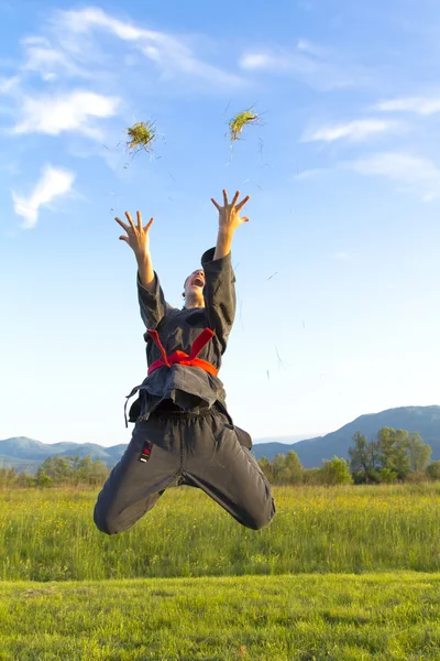 Ninja chica lanzando hierba — Foto de Stock
