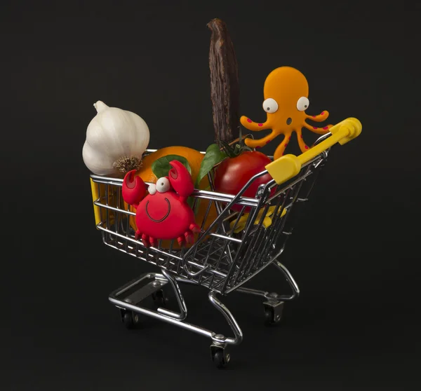 Metallo shopping troley, giocattoli e cose divertenti, isolato sul buio — Foto Stock
