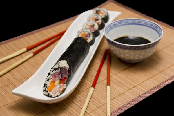 Sushi served with soya sauce and chopsticks, on dark background — Stock Photo, Image