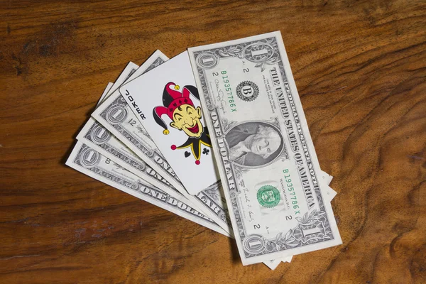 Доллары с карточкой Джокера, на старинном коричневом фоне — стоковое фото