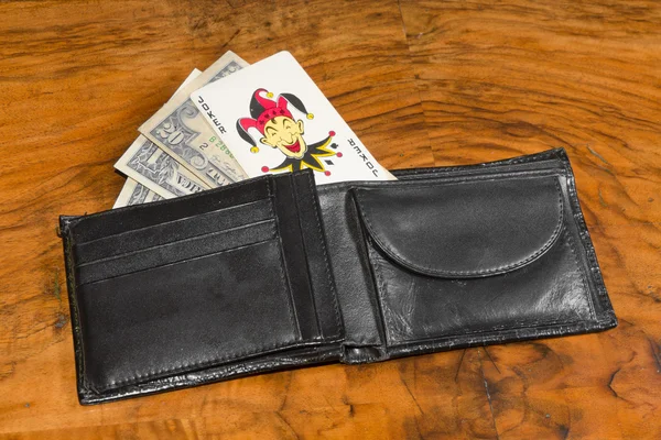 ヴィンテージ ・ ブラウン バック グラウンド上のオープン財布でカードのジョーカーとドル — ストック写真