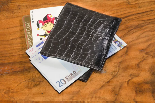 Euro med joker och kasinomedlemmar kort i svart läder plånbok, på vintag — Stockfoto