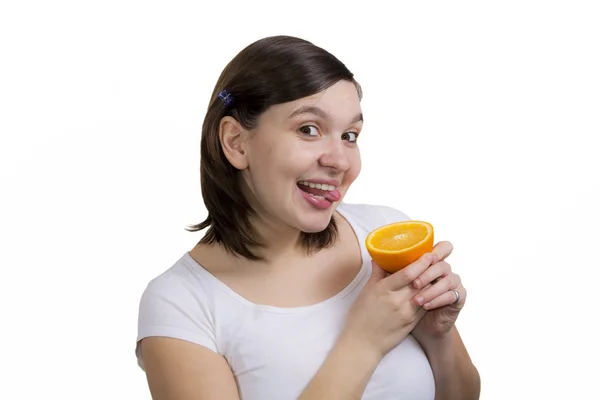 Cute smilling girl licks fresh orange — Stock Photo, Image