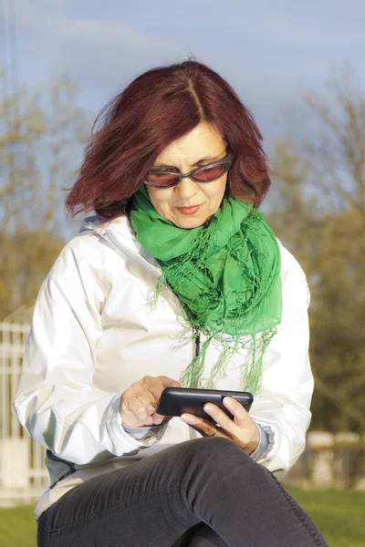 Mujer de mediana edad bien parecido con teléfono tableta —  Fotos de Stock