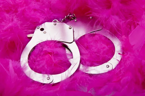 Handschellen an rosa Federn — Stockfoto