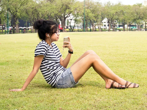 Una joven con auriculares al aire libre. Escuchar música —  Fotos de Stock