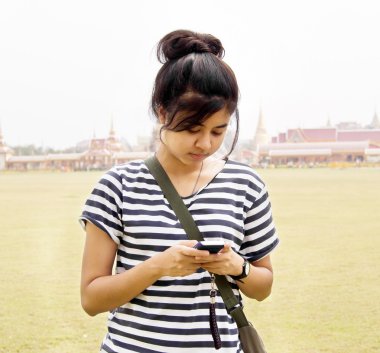 Woman sending / receiving a text message / email on her mobile /