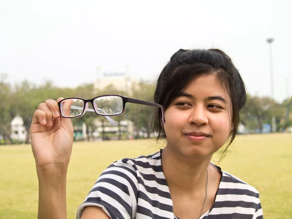 Chica probando sus gafas y mirando su suciedad — Foto de Stock