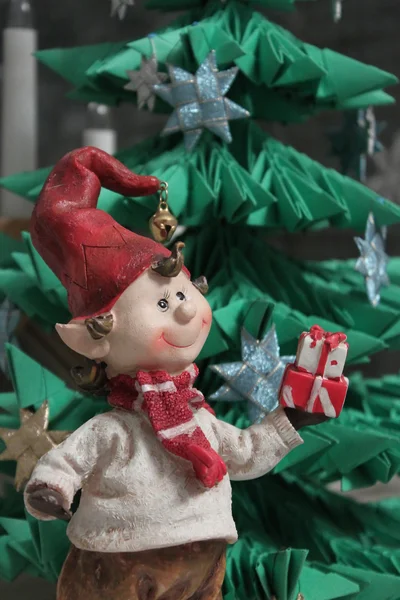 Christmas elf giving a present under christmas tree — Stock Photo, Image
