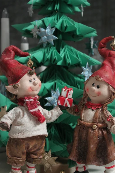Christmas elfs boy and girl giving a present under christmas tre — Stock Photo, Image