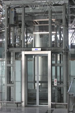 Big glass luggage elevator in the airportr clipart