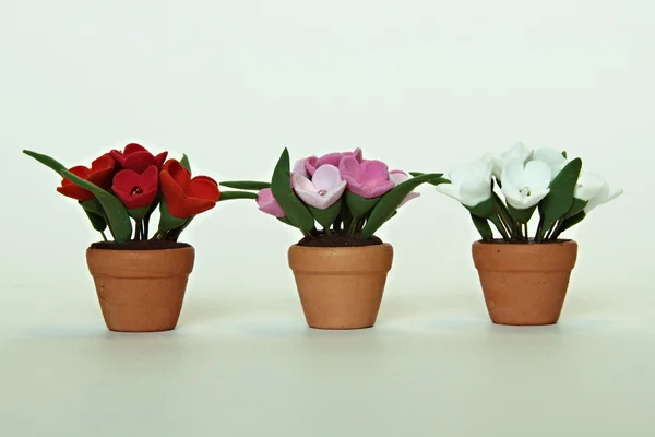 Drei Töpfe mit künstlichen Blumen — Stockfoto