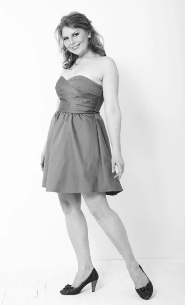Studioaufnahme eines schönen Plus-Size-Modells in blauem Kleid, das Stockbild
