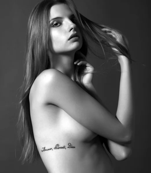 Porträt der sexy kaukasischen jungen Frau mit langen Haaren, Tätowierung "bin Stockfoto