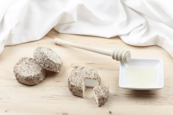 stock image Goat cheese fresh sesame seeds, honey on wooden cutting board