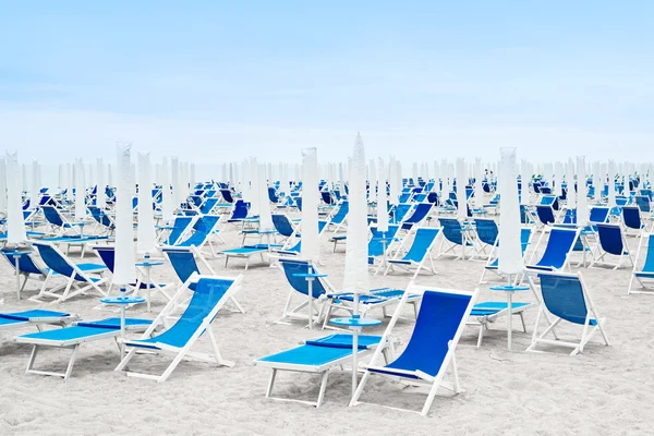 Sonnenschirme und blaue Liegestühle — Stockfoto