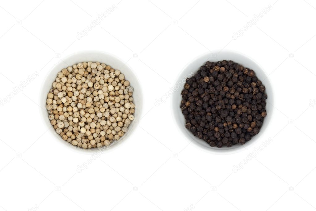 Black and white peppercorn in a cup isolated on background
