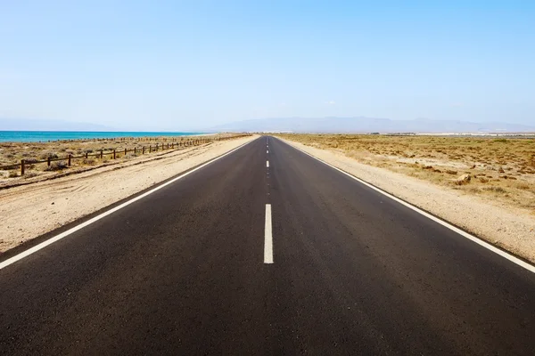 Straight road in desertic seascape. Andalusia. — Stock Photo, Image