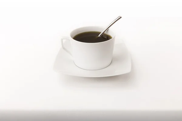 Stock image Cup of tea with a spoon on a white tablecloth