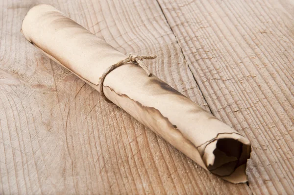 An old scroll on an old wooden background — Stock Photo, Image