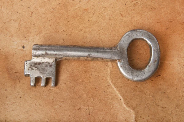 stock image The old key on the background of the old paper