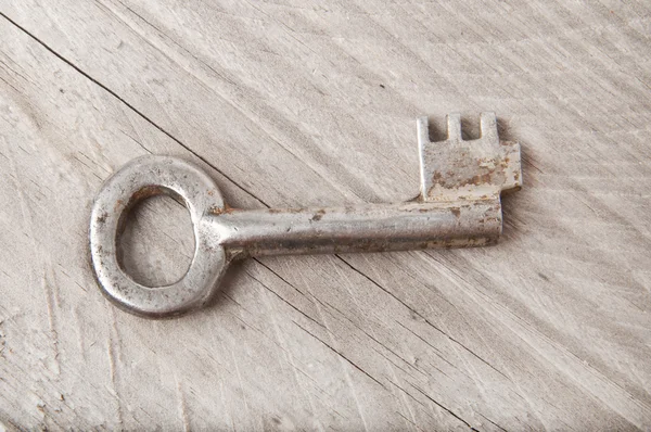 Starý klíč na dřevěné pozadí — Stock fotografie