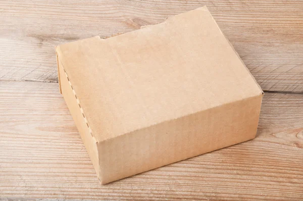 Бумажная коробка на деревянном фоне — стоковое фото