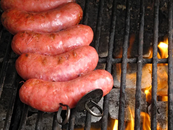 Saucisses grillées sur le gril, avec de la fumée dessus — Photo