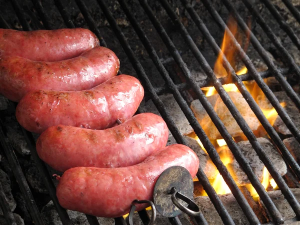 Grilled sausages on grill, with smoke above it Stock Photo