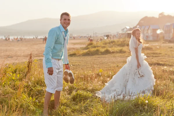 Glad stökigt bruden och brudgummen på stranden — Stockfoto