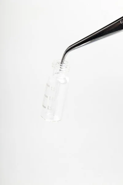 Kromatografiska injektionsflaska och pincett på vit — Stockfoto