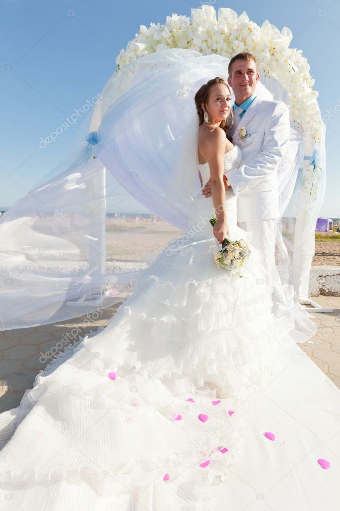 Bride and groom in front of arch