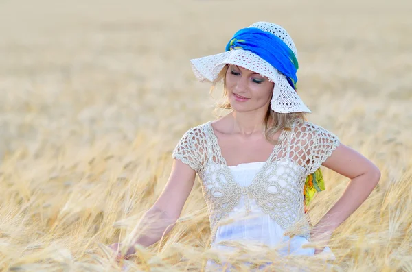 Young beautiful woman on golden cereal field in summer — Stock Photo, Image