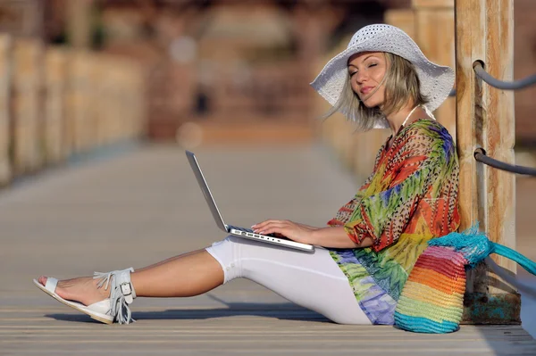Молодая женщина использует ноутбук на открытом воздухе летом — стоковое фото