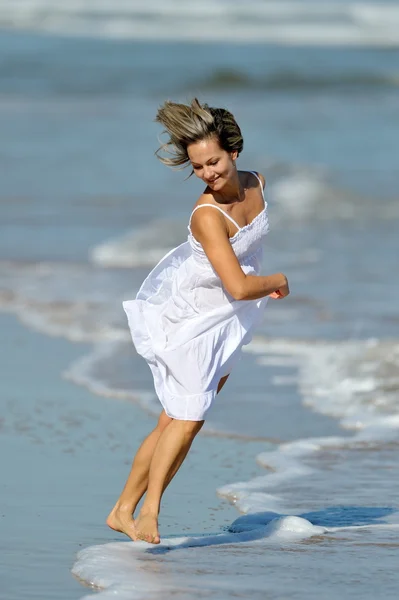 Молода жінка біжить на пляжі — стокове фото