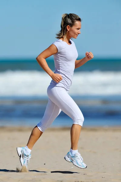 年轻女子在海滩上慢跑 — 图库照片