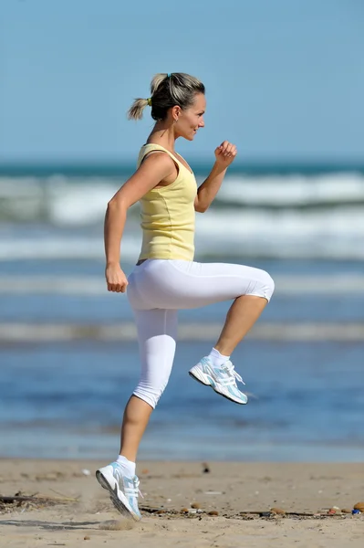 Młoda kobieta jogging na plaży — Zdjęcie stockowe